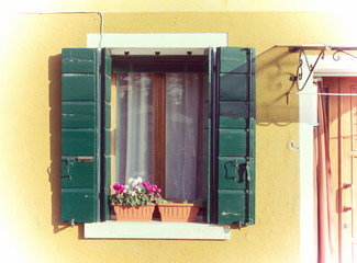 green shutters in a rustic window