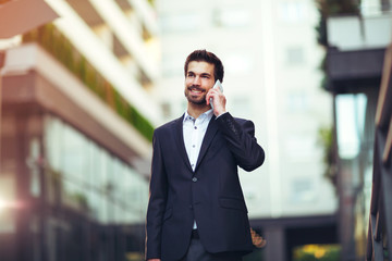 Young businessman talking on his phone outdoors