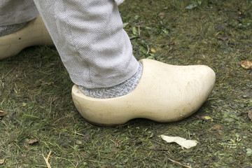 close up from a man's feet with traditional wooden clogs in a meadow