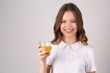 Girl posing with glass of juice. Close up. White background