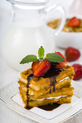Waffles with strawberries and chocolate.