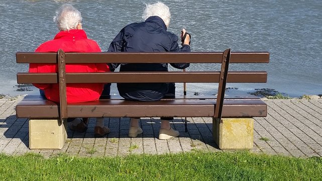 Älteres Ehepaar auf Bank am Wasser