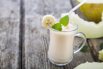 Yogurt and smoothie with melon on a wooden table.