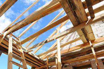 New residential construction home framing against a blue sky. Roofing construction. installation of...