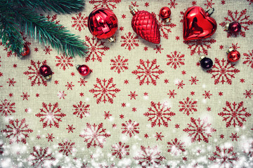 Red Christmas ornaments and xmas tree on canvas background with red glitter snowflakes. Xmas card. Happy New Year. Space for text