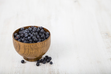 Fototapeta na wymiar Blueberries in a wooden bowl on a wooden table