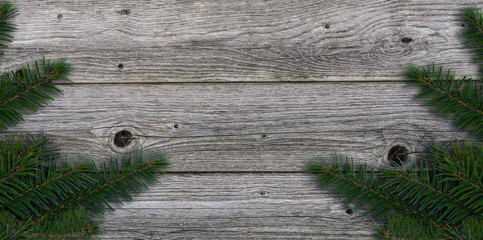 weathered grey wood with fir twigs at the edges