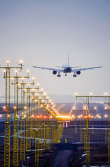 Airplane landing at the airport runway in evening