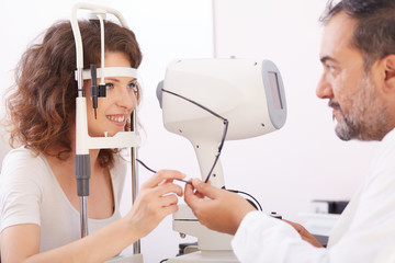 Optometrist in exam room with woman in chair