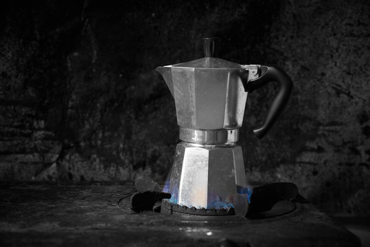 Espresso maker on stove with dark background