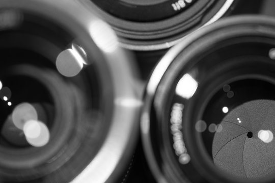 closeup macro of camera lenses with reflections low key black and white image with aperture blades