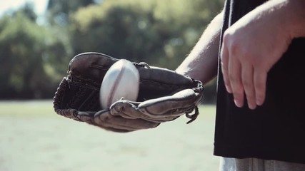 Close Up of Man Wearing Baseball Glove and Tossing Baseball from Hand to Hand During Baseball Game Outdoors in Field on Sunny Day in Summer 4K.