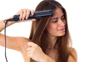 Woman using hair straightener 
