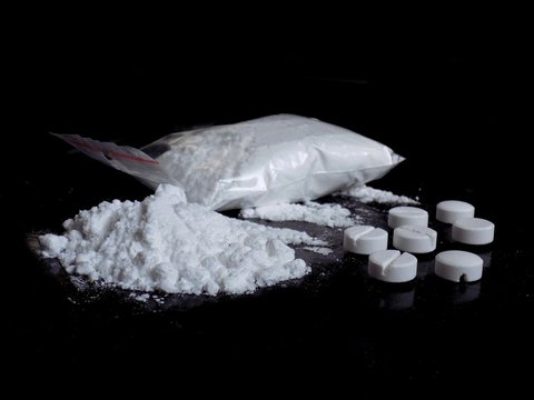 Cocaine drug powder bag, pile and lines, pills on black background