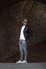 Obraz premium cool posing young man fashion leather jacket casual clothes jean