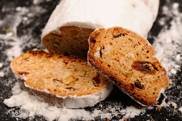Stollen christmas cake with sugar icing on stone plate