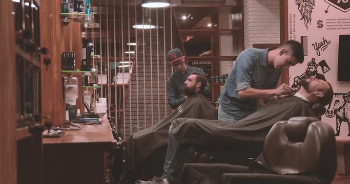 Hairdressing process at barbershop top view 4k video. Barbers cutting beard with clipper of client man lumberjack