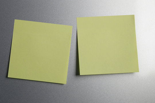 Empty yellow paper sheet on refrigerator door for design.