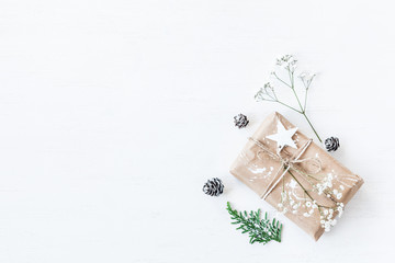 Christmas composition. Christmas gift, pine cones, thuja branches and gypsophila flowers. Top view,...