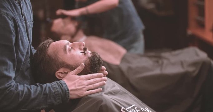 Barber grooming mustache curls and beard in barbershop 4k close-up video. Bearded lumberjack style man