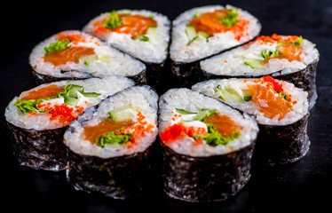 Japanese rolls with fish on a black background