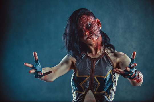 Zombie woman with the blood on the face and hands.