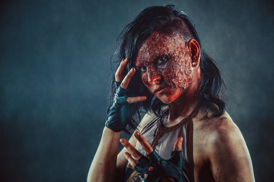Portrait of Zombie woman with the blood on the face and hands.