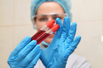 Nurse works with blood test tubes, testing blood for viruses. Coronavirus COVID-19 background