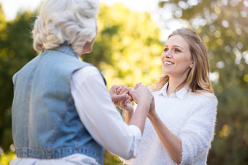 Fototapeta premium Joyful young woman holding her mother hands.