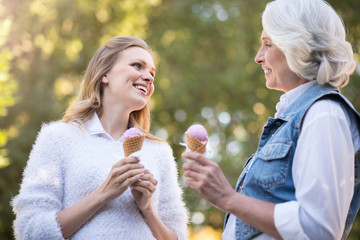 Fototapeta premium Two happy woman laughing and eating ice cream.
