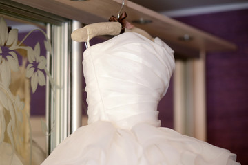 Beautiful white wedding dress for bride indoors. Beauty of bridal gown for marriage. Female lace clothes for celebration
