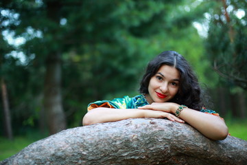 Beautiful gypsy girl in traditional dress at a tree in the park