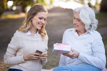 Two happy smiling women sitting on the ground.