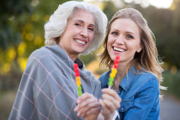 Two smiling happy woman showing lollypop.