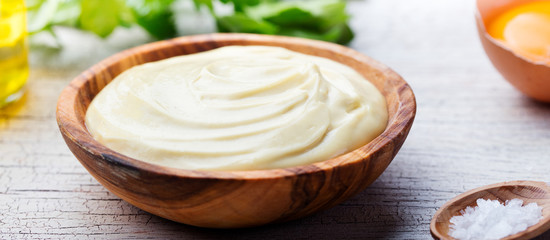 Homemade mayonnaise, mayo in a wooden bowl. White background.