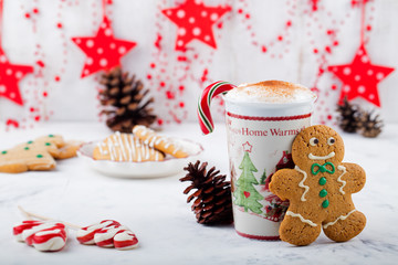 Gingerbread cookie man and hot cup of cappuccino. Traditional Christmas dessert. Copy space