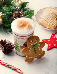 Gingerbread cookie man and hot cup of cappuccino. Traditional Christmas dessert. Copy space