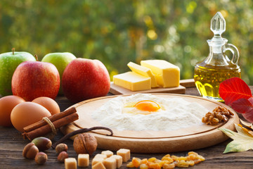 Making apple pie outdoor. Ingredients on rustic wooden board.