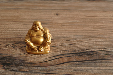 Figurine of laughing and cheerful golden Buddha
