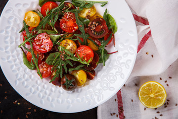 salad of fresh,colored cherry tomatoes with arugula and lemon dressing.selective focus.