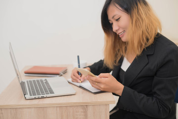 young business woman sitting at workplace and Writing notes in a