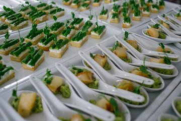 Pieces of meat lie over white spoons