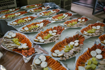 Serving dishes with fish and potatoes stand on the table