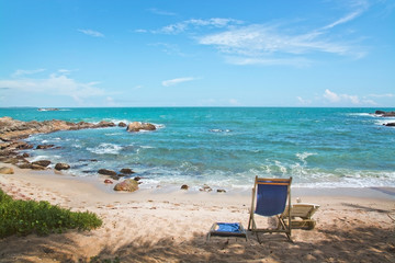 Simple chair on sandy beach by Indian Ocean on a beach in Sri Lanka, Asia.