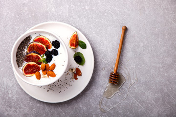 Homemade yoghurt, sour cream with fresh figs,fresh blackberries,Chia seeds and nuts almonds and mint.Healthy Breakfast.Food or Healthy diet concept. selective focus.