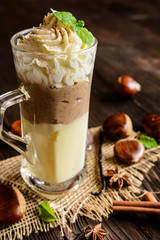 Vanilla pudding with chestnuts puree and whipped cream in a glass jar