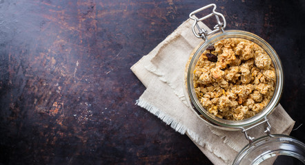 Homemade muesli granola in a jar on rusty black table