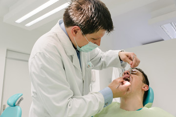 Dentist is examining his patient
