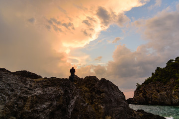 Silhouette of a man against sunset with clouds