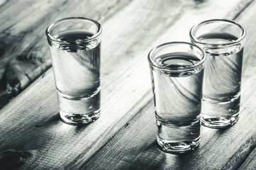 Crédence de cuisine en verre imprimé Bar Vodka shots filled with alcohol on wooden black bar.